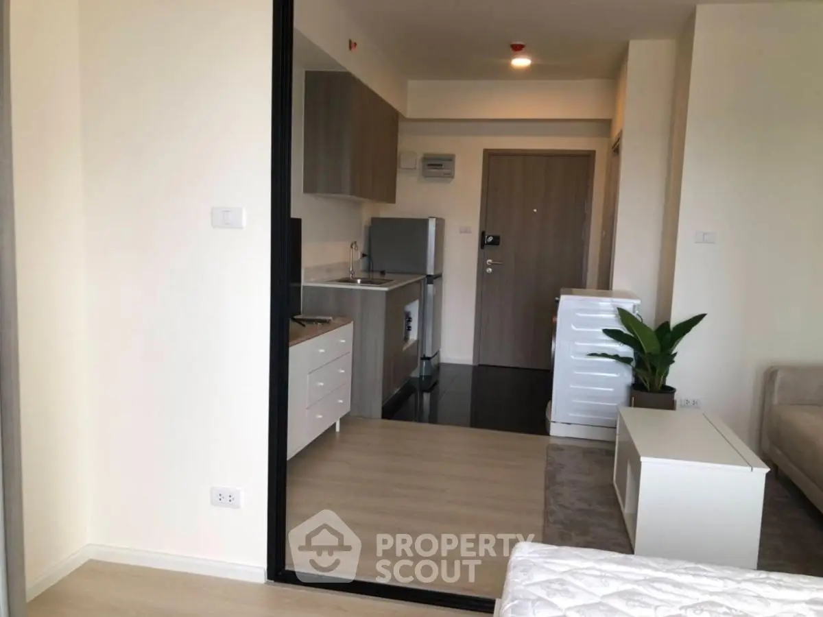 Modern studio apartment with compact kitchen and cozy living area.