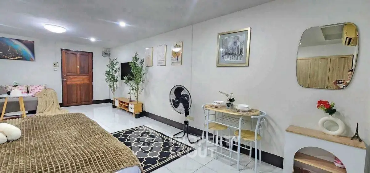 Cozy living room with modern decor, featuring a small dining area and stylish furnishings.