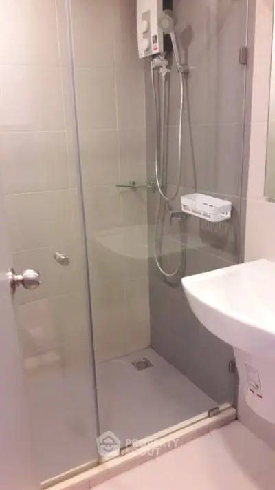 Modern bathroom with glass shower enclosure and sleek fixtures.