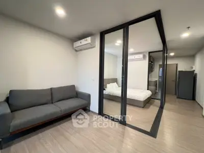 Modern apartment interior with cozy living room and bedroom, featuring sleek design and ample natural light.