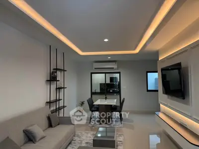 Modern living room with stylish decor and open dining area, featuring ambient lighting and sleek furniture.