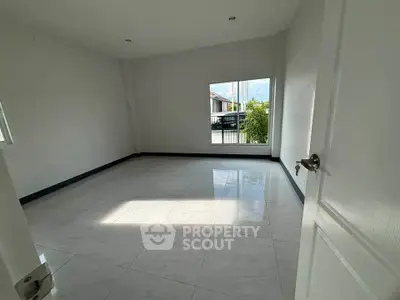 Spacious empty room with large window and glossy tiled floor, perfect for customization.