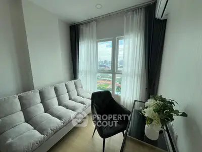 Stylish modern living room with city view, featuring a cozy sofa and elegant decor.