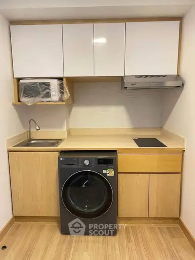 Modern compact kitchen with integrated washing machine and sleek cabinetry