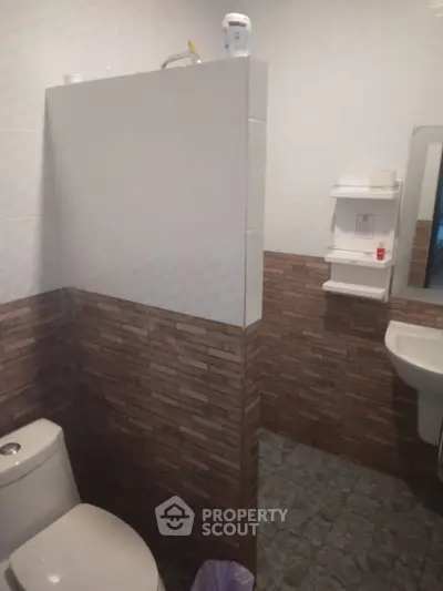 Cozy bathroom with modern tile design and essential fixtures.