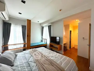 Spacious bedroom with modern decor and natural light, featuring a cozy bed and stylish furnishings.