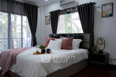 Cozy bedroom with large windows, stylish decor, and a comfortable bed, perfect for relaxation and rest.