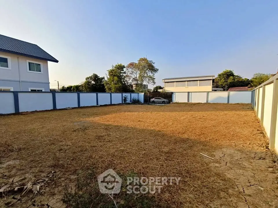 Spacious vacant land plot with boundary walls in a serene residential area, ideal for building a dream home.