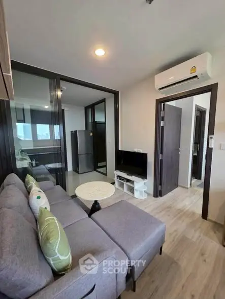 Modern living room with cozy sofa, TV, and air conditioning in a stylish apartment.