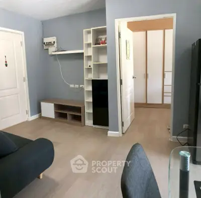 Modern living room with minimalist furniture and open doorway to bedroom