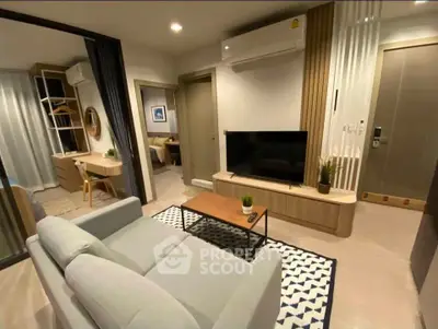 Modern living room with stylish decor and open view to bedroom, featuring sleek furniture and neutral tones.