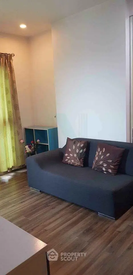 Cozy living room with stylish sofa and wooden flooring, perfect for relaxation and modern living.