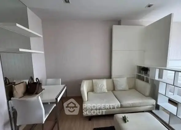 Modern living room with white sofa and dining area in open layout apartment.