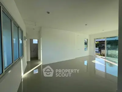 Spacious empty room with large windows and glossy floors, perfect for customization.