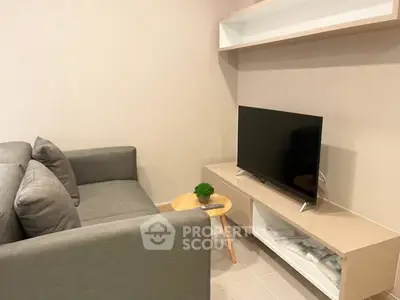 Modern living room with sleek gray sofa and flat-screen TV on stylish stand.