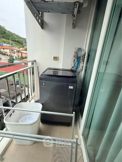 Compact balcony with washing machine and scenic view, perfect for urban living convenience.