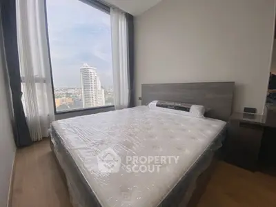 Spacious bedroom with large window offering stunning city view