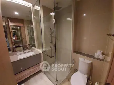 Modern bathroom with glass shower and sleek fixtures in a contemporary apartment.