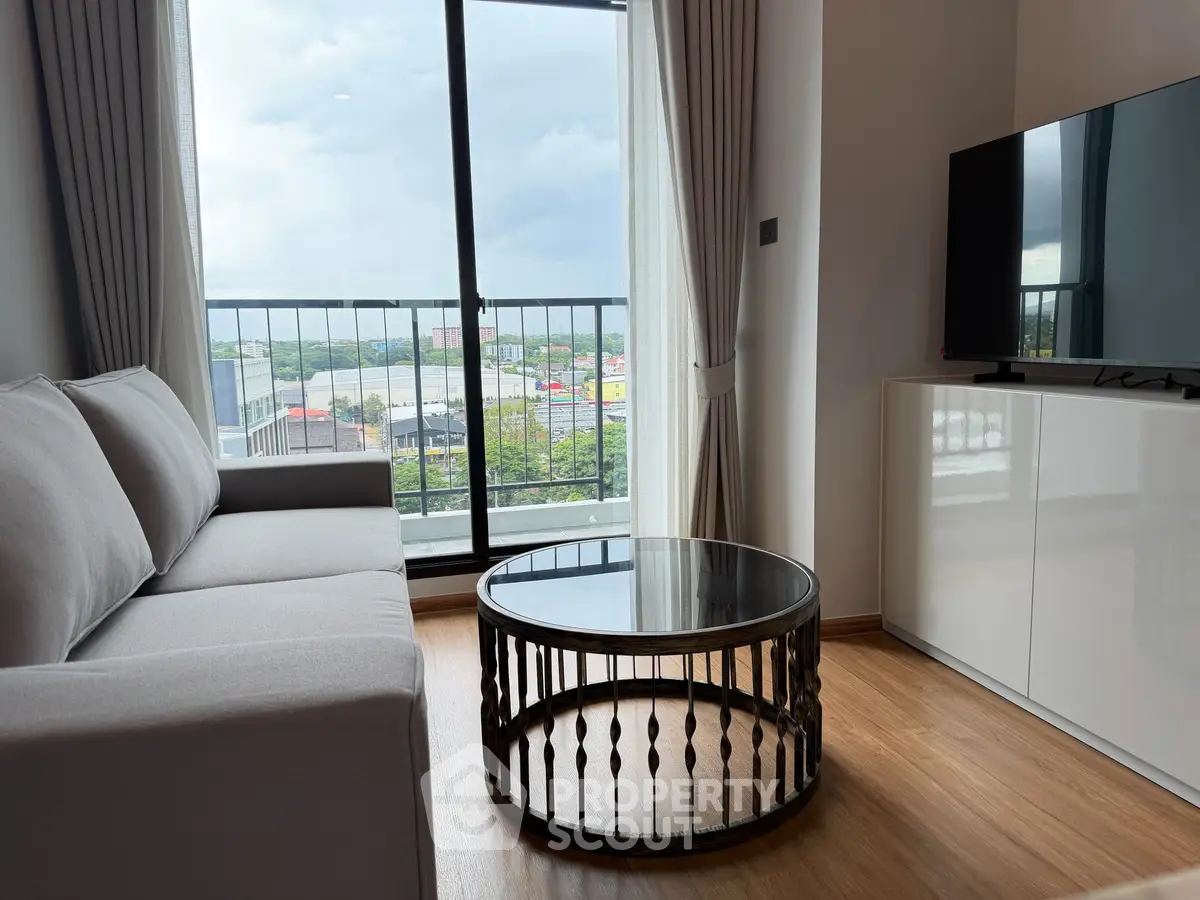 Modern living room with large window and city view, featuring a sleek sofa and stylish coffee table.