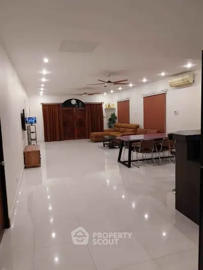 Spacious living room with modern furniture and elegant lighting, perfect for family gatherings.