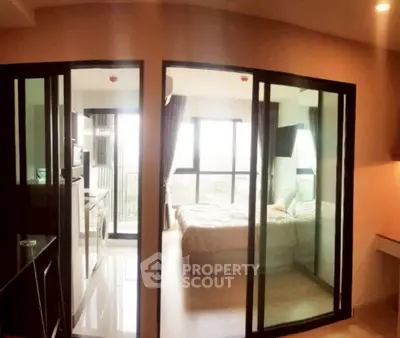 Modern apartment with glass sliding doors, cozy bedroom, and bright interior design.