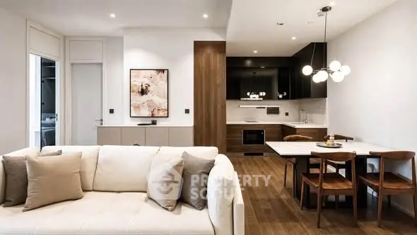 Modern open-plan living room and kitchen with stylish decor and elegant lighting.