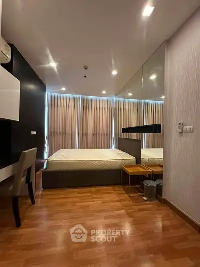Modern bedroom with large windows and stylish decor in a high-rise apartment.