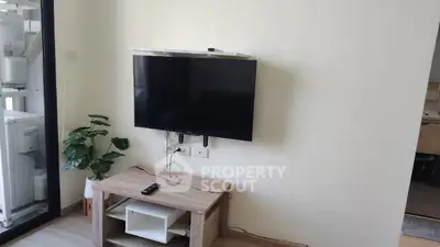 Modern living room with wall-mounted TV and stylish wooden furniture, perfect for cozy entertainment.