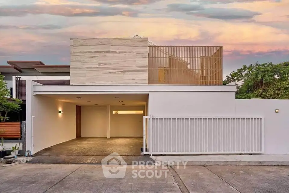 Modern minimalist house exterior with sleek design and spacious driveway at sunset