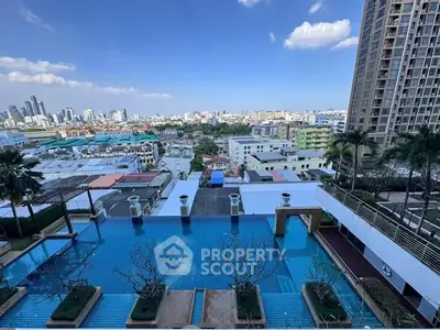 Stunning cityscape view from rooftop pool area with clear blue skies.