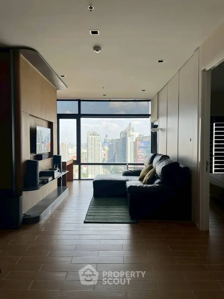Modern living room with stunning city view, featuring sleek furniture and large windows.