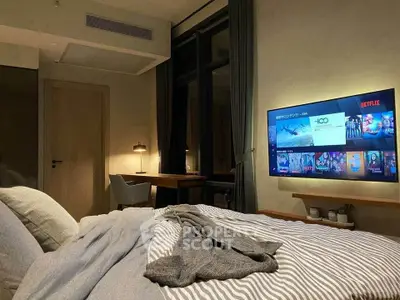 Cozy bedroom with modern decor and wall-mounted TV, perfect for relaxation and entertainment.