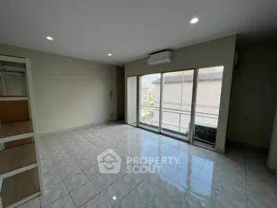 Spacious living room with large windows and air conditioning, perfect for natural light and comfort.