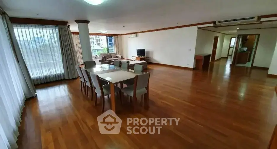 Spacious open-plan living and dining area with wooden flooring and modern furniture.