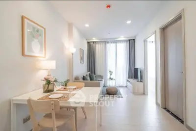 Modern living room with dining area, stylish decor, and natural light.