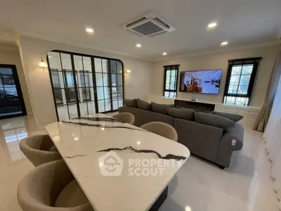 Spacious modern living room with elegant marble dining table and cozy sofa, perfect for relaxation and entertainment.