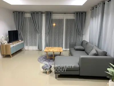 Spacious living room with modern gray sectional sofa and stylish decor