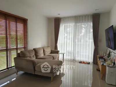 Modern living room with cozy sofa and large windows offering natural light.