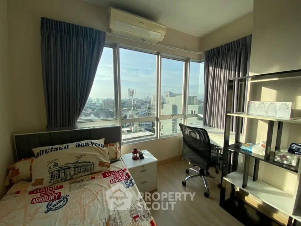 Bright bedroom with city view, featuring modern decor and ample natural light.