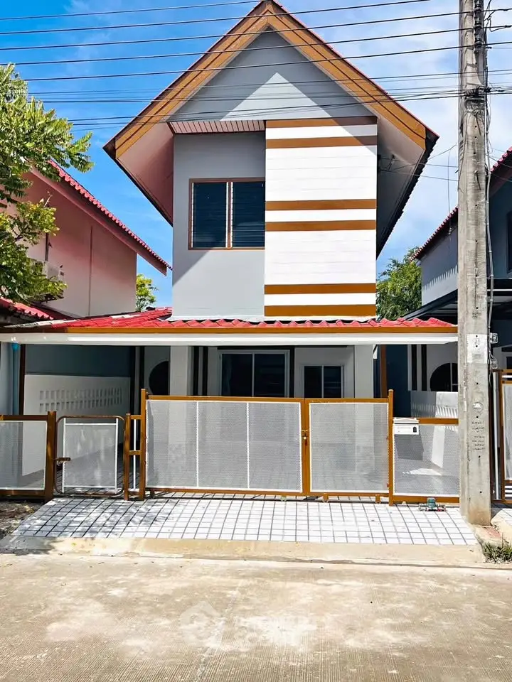 Charming two-story house with modern facade and gated entrance in a serene neighborhood.