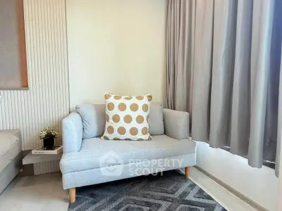 Cozy living room with stylish sofa and polka dot cushion, perfect for relaxation.