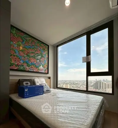 Modern bedroom with large window offering stunning city views and vibrant wall art.
