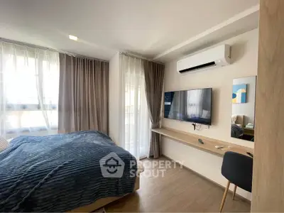 Modern bedroom with large windows, air conditioning, and wall-mounted TV