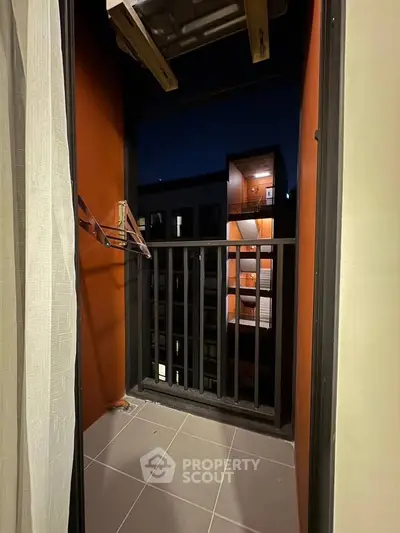 Cozy balcony with nighttime city view, perfect for relaxation and enjoying the urban skyline.