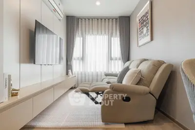 Modern living room with sleek furniture and large TV, perfect for relaxation and entertainment.