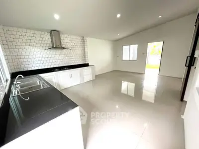 Spacious modern kitchen with sleek black countertops and white tile backsplash