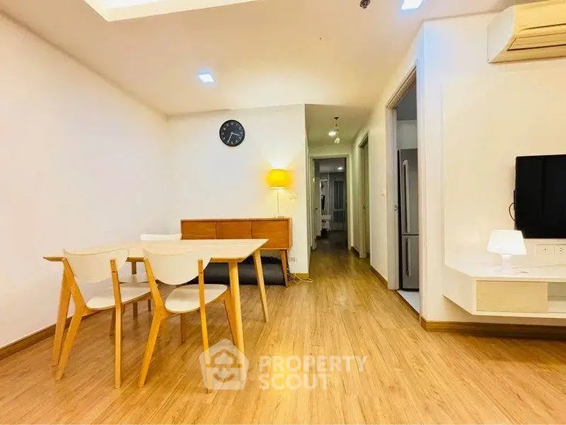 Modern living room with wooden flooring and minimalist furniture in a cozy apartment.