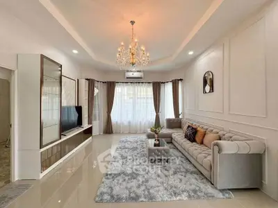 Elegant living room with chandelier, plush sofa, and large windows for natural light.