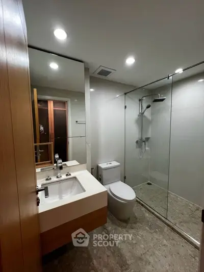 Modern bathroom with glass shower and sleek fixtures in a contemporary home.