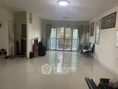 Spacious living room with large windows and glossy tiled floor